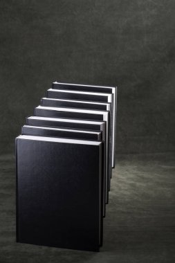 Karanlık bir arkaplanda kitap yığını