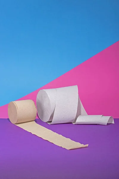 Two rolls of toilet paper on a colored background
