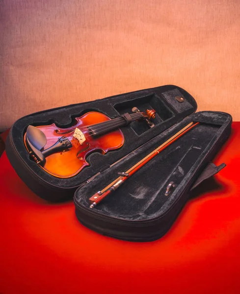 红色桌子上打开的箱子里的小提琴 — 图库照片