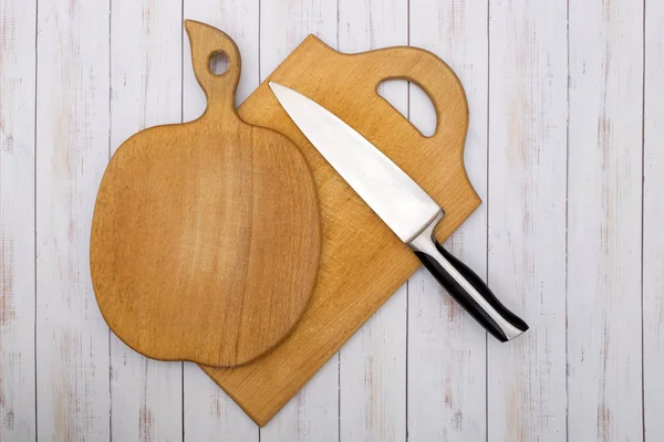 Two wooden kitchen chopping boards with a knife