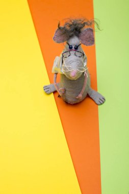 Fare - renkli bir arka planda keçeli yünden yapılmış yumuşak oyuncak