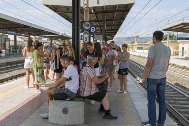 Sesto Fiorentino, İtalya - 21 Ağustos 2019: İtalya 'nın Sesto Fiorentino kentindeki bir tren istasyonunda insanlar tren bekliyor
