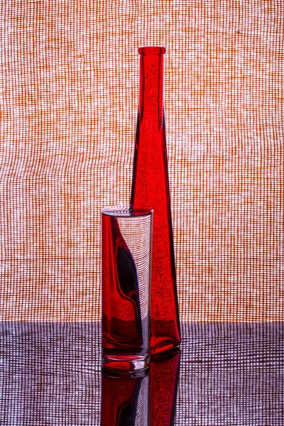 まだ赤いボトルと水のガラスとの生活 — ストック写真