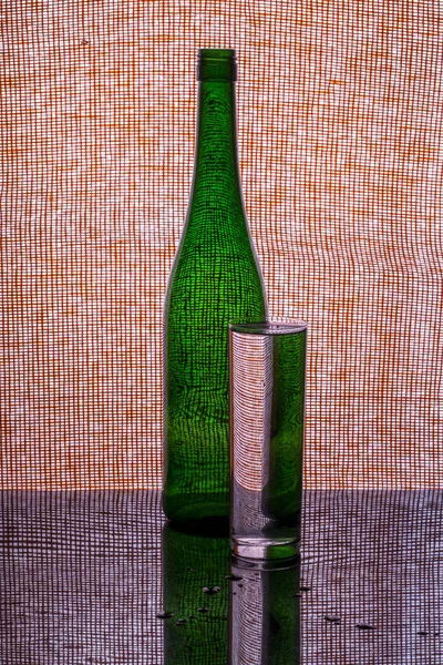 Natureza morta com uma garrafa verde e um copo de água — Fotografia de Stock