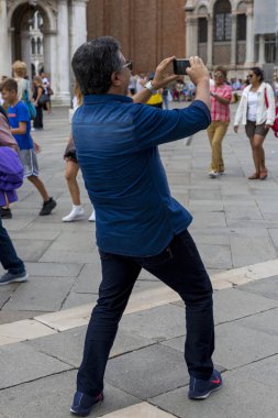 Venedik, İtalya - 22 Ağustos 2019: Bir adam akıllı telefondan Venedik 'in görüntülerini çekiyor