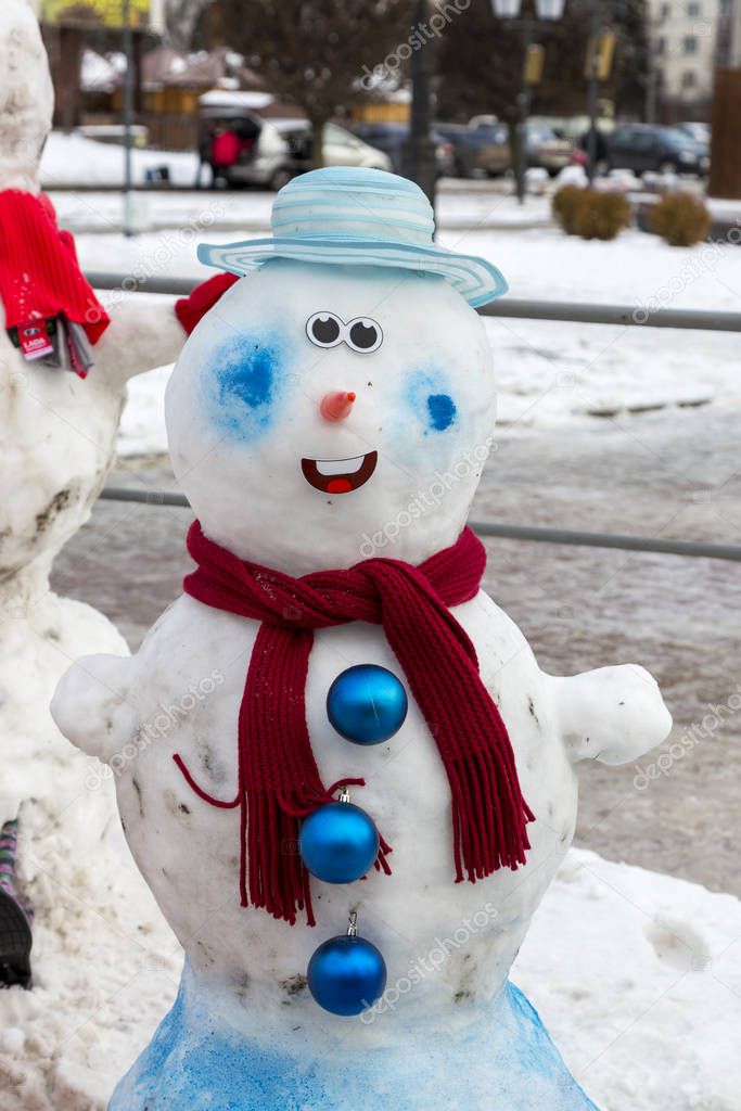 Head and torso of a decorated snowman on a winter street