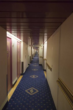 Modern yolcu feribotunun güvertesinde kabin kapıları olan uzun bir koridor.