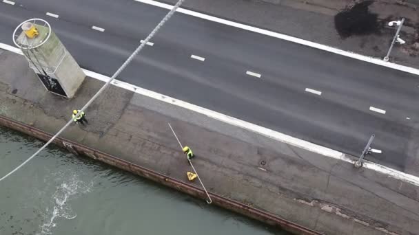 Twee werkhavens zorgen voor de aanlegplaats van een passagiersveerboot in Helsinki. Uitzicht vanaf de zijkant van de veerboot. Stockvideo