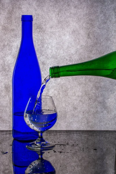 Häll Vätska Från Grön Flaska Ett Glas — Stockfoto