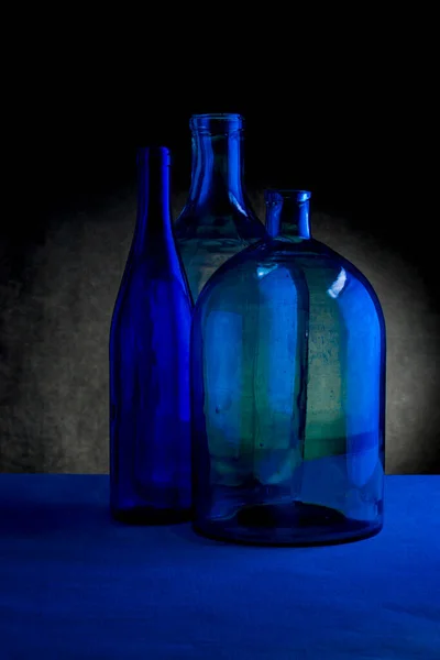 Stillleben Mit Drei Glasflaschen Auf Dunklem Hintergrund — Stockfoto