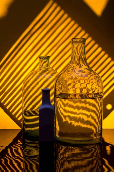 Still Life Glass Bottles Yellow Background Shadows — Stock Photo, Image