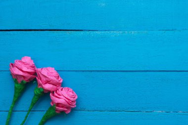 Turkuaz ışık hüzmesi taze gül çiçek ahşap arka plan boyalı. Seçici odak. Metin için yer.
