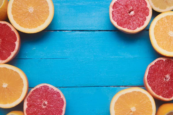 Taze narenciye ahşap mavi zemin üzerine yeşil yaprakları ile