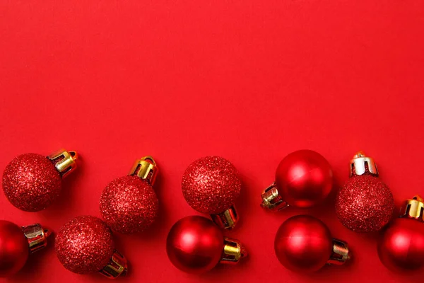 Composición de la tarjeta de felicitación de Navidad. Navidad bolas rojas decoraciones sobre fondo rojo. Plano, vista superior, espacio para copiar —  Fotos de Stock