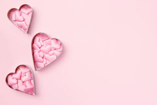 3 kotters koekjes in hartvorm met confetti op pastelroze ondergrond. Onderwerp Valentijnskaart. Bovenaanzicht, kopieer ruimte voor tekst. — Stockfoto