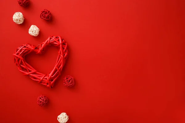 Cuori in rattan con decorazione su sfondo rosso posa piatta. Concetto di celebrazione di San Valentino . — Foto Stock