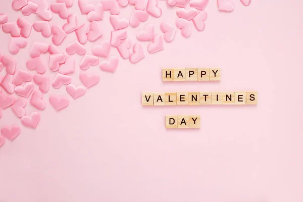 Cuore Confetti su sfondo rosa pastello con lettere in legno. Giorno di San Valentino concetto di biglietto di auguri. Vista dall'alto, disposizione piatta, spazio di copia . — Foto Stock