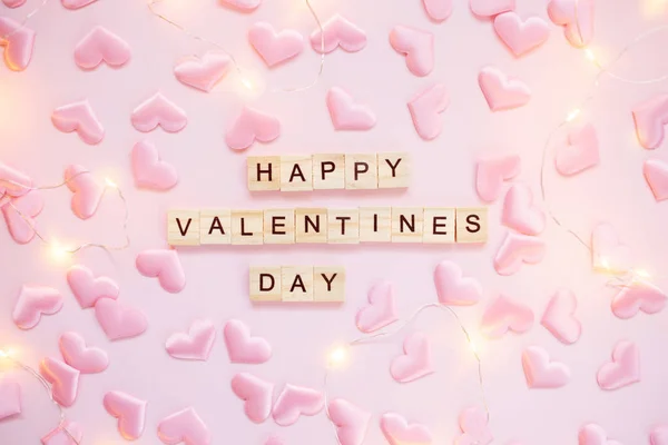 Cuore e luci Confetti su sfondo rosa pastello con lettere in legno. Giorno di San Valentino concetto di biglietto di auguri. Vista dall'alto, piatta . — Foto Stock