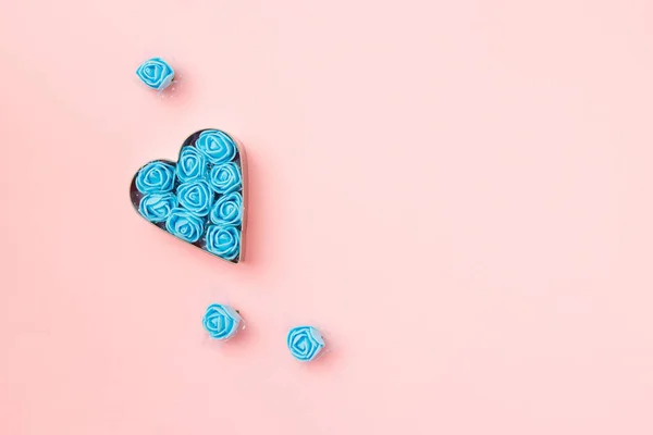 パステルピンクの背景に青いバラでハート型のカッタークッキー。コンセプトバレンタインのカード。トップ表示、テキストのコピースペース. — ストック写真