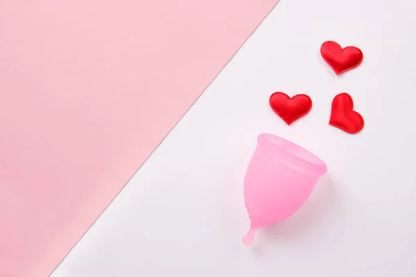 Copa menstrual rosa y corazones confeti sobre fondo rosa y blanco. Piso tendido, vista superior, espacio para copiar. Concepto de período mujer — Foto de Stock