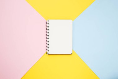 Not defteri mavi ve sarı arka planda. Düz yatış, üst görünüm.