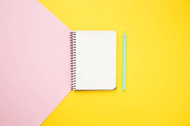 Not defteri mavi ve sarı arka planda. Düz yatış, üst görünüm.