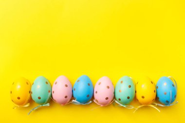 Paskalya yumurtaları sarı arka planda sınırdır. Minimum Paskalya tebrik kartı konseptin kutlu olsun. Üst görünüm, düz görünüm, kopyalama alanı