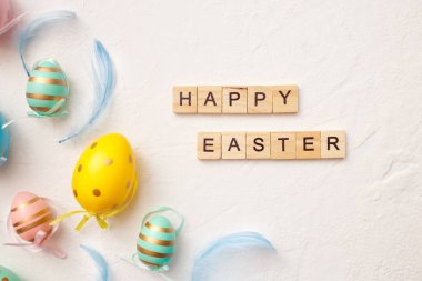 Beyaz arka planda tüyleri olan Paskalya yumurtaları. Minimum Paskalya tebrik kartı konseptin kutlu olsun. Üst görünüm, düz görünüm, kopyalama alanı