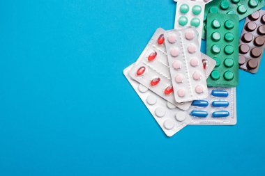 Mavi arka planda su toplayan haplar. Düz konum, kopyalama alanı, üst görünüm. Sağlık kavramı