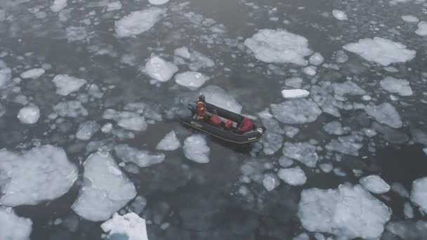Le persone in barca spedizione navigano in ostacoli ghiaccio sfacciato. Vista aerea dall'alto verso il basso . — Video Stock
