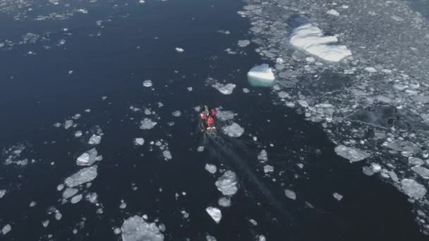 Motorbåt flyter bland Antarktis isflak och isberg. Flygspårning. — Stockvideo