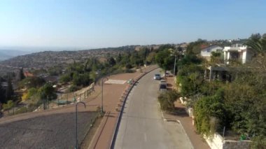 Temiz gökyüzü olan bir köyün üzerinde uçan hava, kırmızı evleri olan binalar ve arka planda yeşil tepeler. Katzir, İsrail 'in yukarıdan görüntüsü