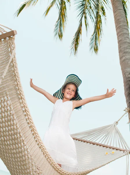 Klein meisje in een hangmat op het strand — Stockfoto