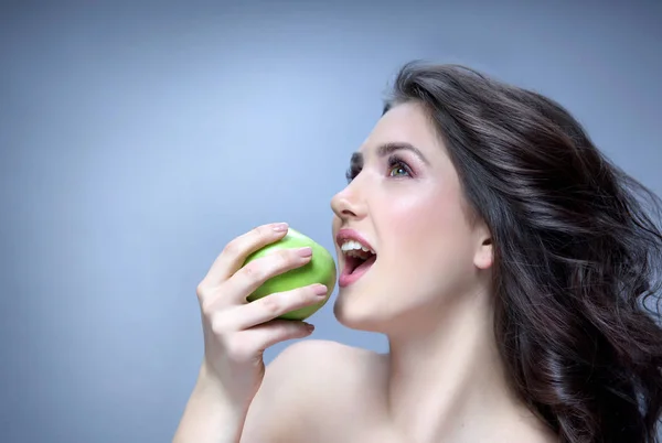 Mooie vrouw eten groene appel — Stockfoto