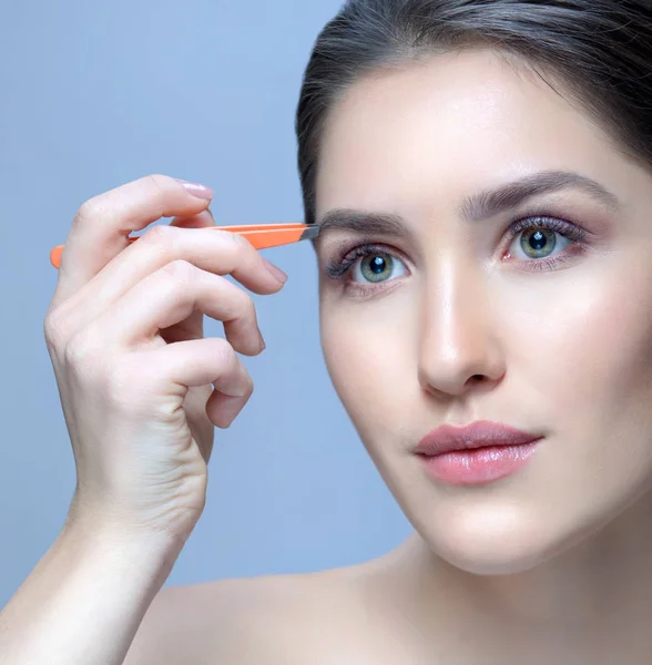 Beautiful Woman Plucking her Eyebrows