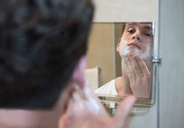 Junger Mann rasiert sich — Stockfoto