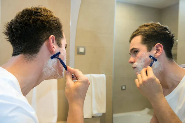 Young man shaving — Stock Photo, Image