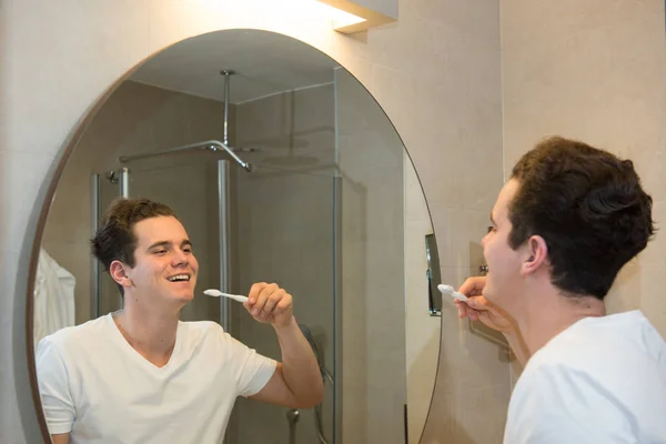 Jeune homme brossant les dents Photo De Stock