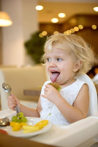 小さな女の子の果物を食べる — ストック写真