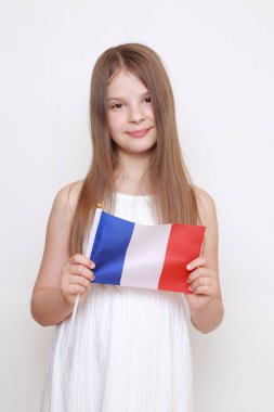 Avrupalı küçük kız elinde Fransız bayrağı tutuyor.