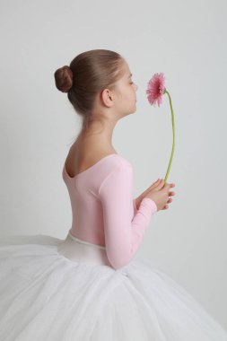 Güzel küçük balerin ve pembe gerbera çiçek