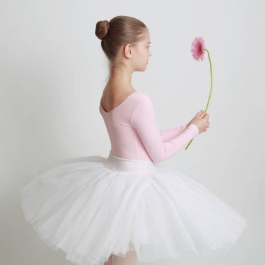 Güzel küçük balerin ve pembe gerbera çiçek
