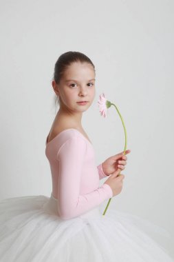 Güzel küçük balerin ve pembe gerbera çiçek