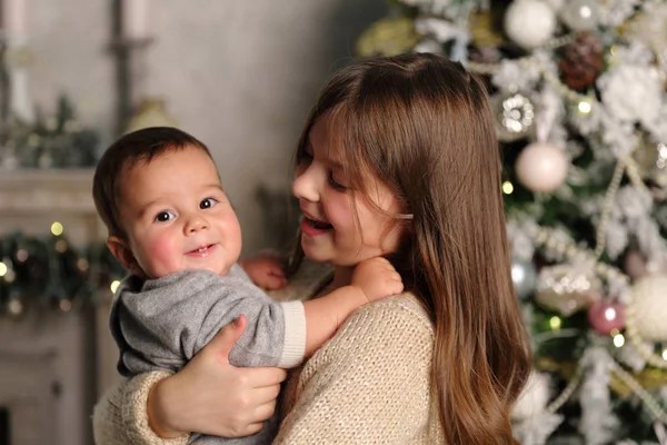 休日のテーマのクリスマス ツリーに姉妹と赤ちゃんの弟 — ストック写真