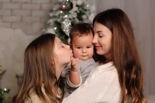 休日のテーマのクリスマス ツリーを娘と赤ちゃんの男の子を持つ母 — ストック写真