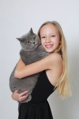 Sevimli beyaz genç kız ve bir İngiliz kısa saç kedi