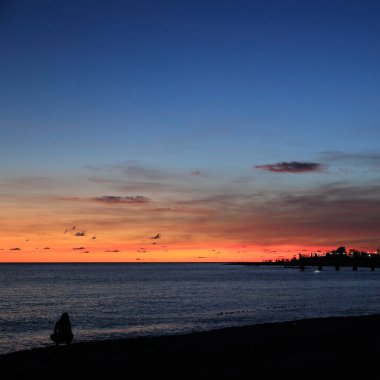 Yaz gün batımı saatinde Soçi'de Karadeniz kıyısında insanların silueti, Rusya Federasyonu. Seçilen Odak.
