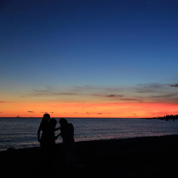 Silhouette of people over Black sea seaside in Sochi at the summer sunset time, Russian Federation. Selected Focus.