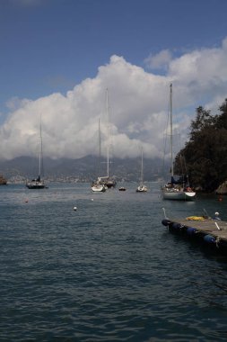 Portofino, İtalya - 5 Nisan 2018: Lüks İtalyan tatiller - güzel Portofino Ligurian kıyısında. Mavi su ve misafir Portofino, köy taç aracılığıyla koy görünümü.