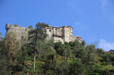 Portofino, İtalya - 5 Nisan 2018: Lüks İtalyan tatiller - güzel Portofino Ligurian kıyısında. Mavi su ve misafir Portofino, köy taç aracılığıyla koy görünümü.